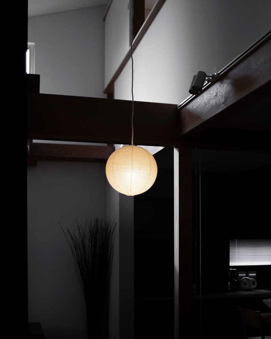 The AKARI 30A glowing in a dark, high-ceilinged loft
