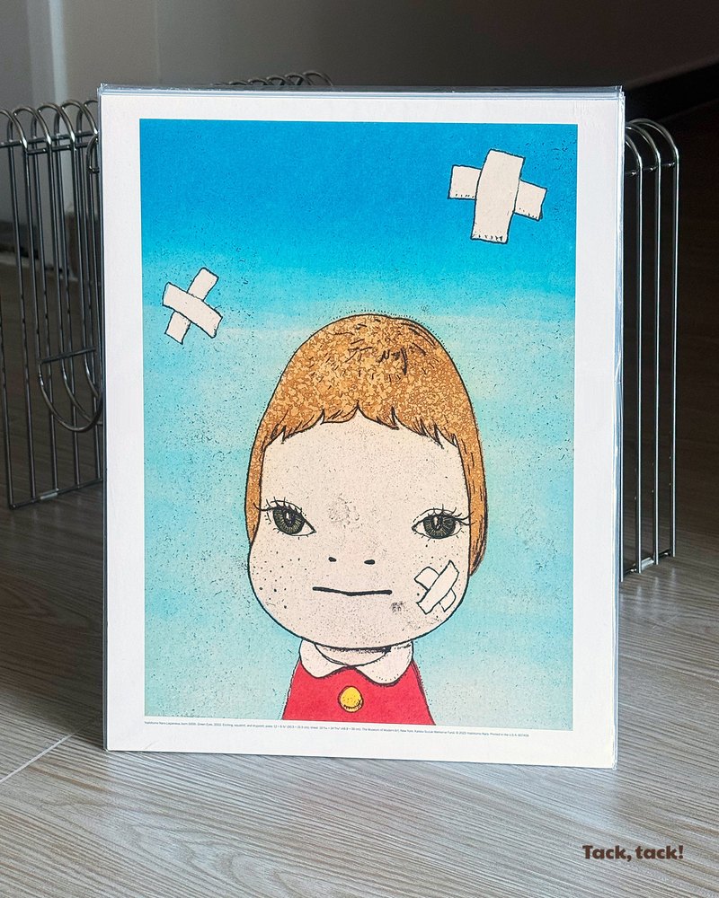 Yoshitomo Nara Green Eyes print in a clear sleeve, standing in a magazine rack, with the Tack, tack! wordmark